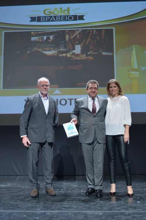 Ο Παύλος Ζορμπάς και η Στεφανία Φλέγγα παραλαμβάνουν το Χρυσό Βραβείο στην κατηγορία «Σχεδιασμός & Λειτουργικότητες Δωματίων» για τα YES!HOTELS από τον Γιάννη Τσεκλένη, μέλος της κριτικής επιτροπής  