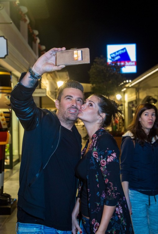  Ο Γιάννης Αϊβάζης και η Μαρία Κορινθίου βγάζουν μία selfie φωτογραφία στα στολισμένα σοκάκια του εκπτωτικού χωριού